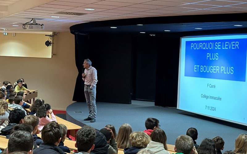 François Carre en pleine présentation, captivant l'attention des élèves de 5ème avec des graphiques sur les bienfaits de l'activité physique.